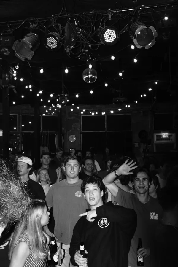 An audience beneath stage lights and a disco ball; stock atmosphere reference